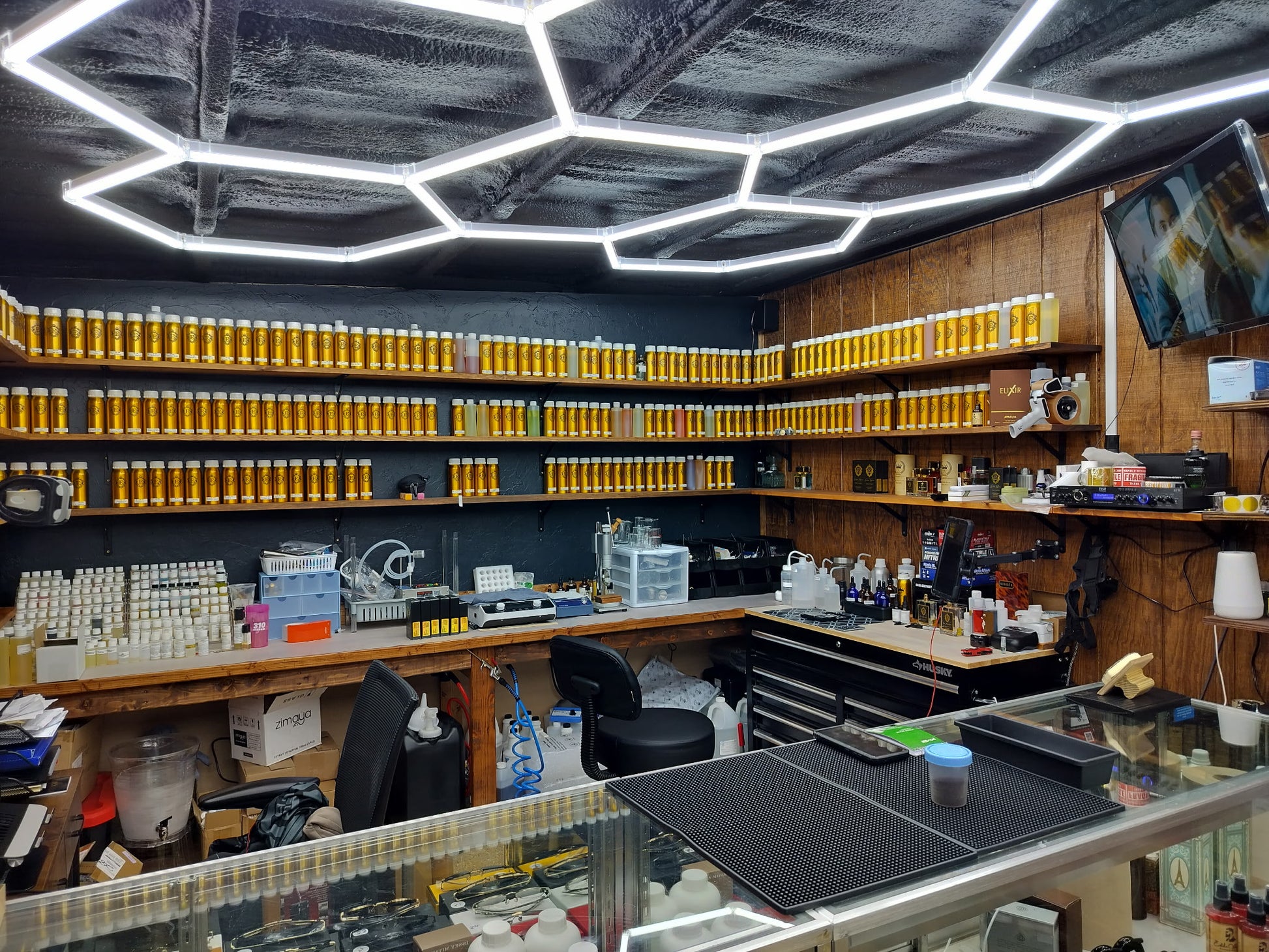 Indoor setting with shelves displaying products, a counter, and hexagonal ceiling lights.
